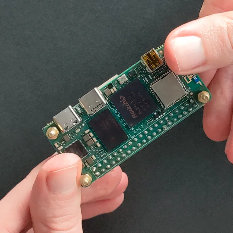 The Radxa Zero 3W single-board computer held in hands, showcasing the Rockchip RK3566 SoC and LPDDR4X RAM chips that power the KVM 2.0.